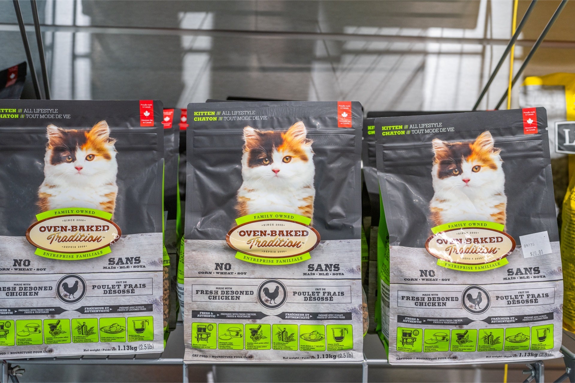 Oven Baked Tradition kitten chicken food bags displayed on a shelf for pet owners