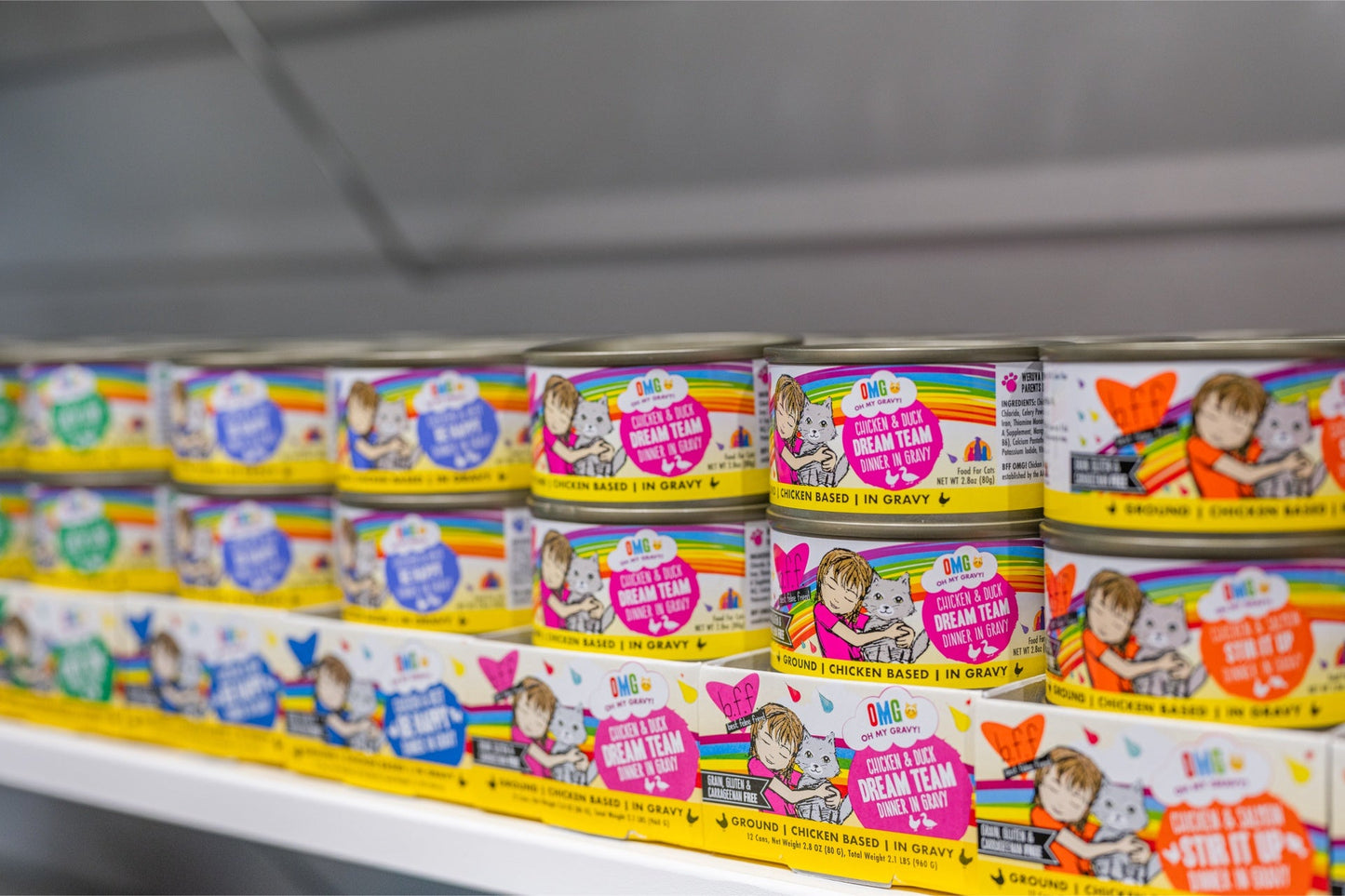 Weruva OMG Stir canned cat food variety pack on store shelf with colorful packaging