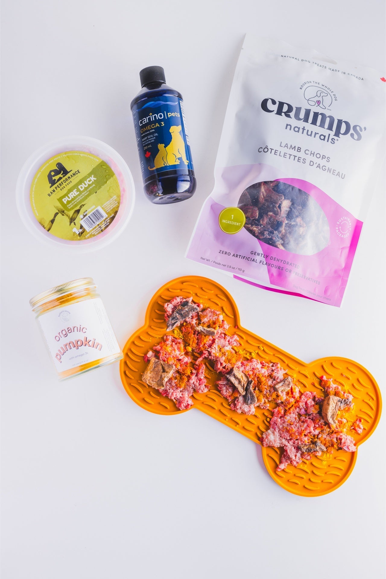 Crumps' Natural dehydrated lamb chop for dogs displayed on a bone-shaped mat with other pet food items