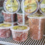 Raw Performance Pure Duck Raw Dog Food in clear containers stacked in a freezer display