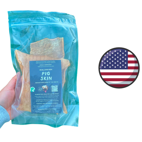 Real Dog Box pig skin dog treats in resealable blue packaging held in hand with American flag icon